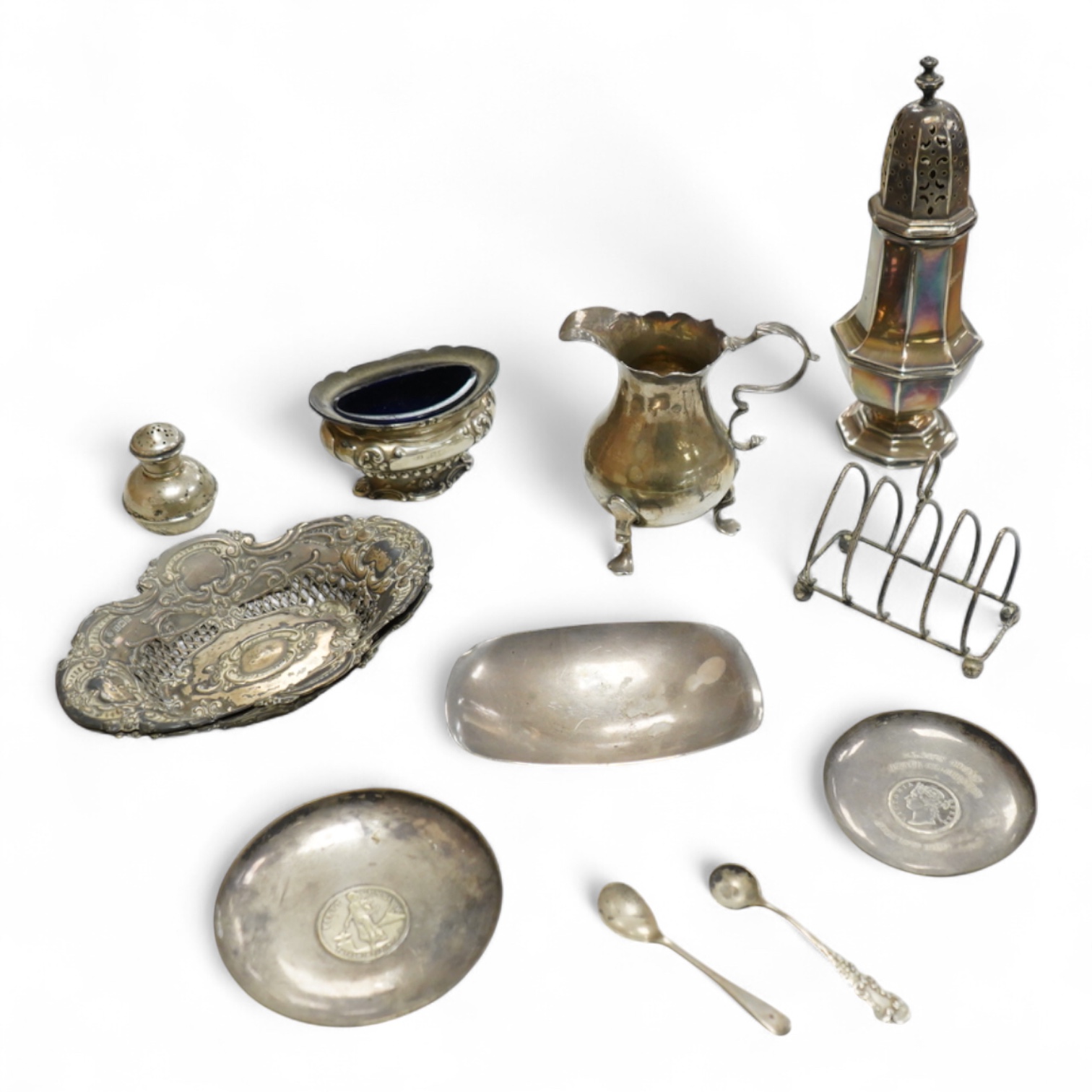 A collection of small silver, including a George III cream jug, London, 1762, 88mm, a George V sugar caster, small five bar toastrack, pair of bonbon dishes, pepperette, dish, two condiment spoons and mustard pot, togeth